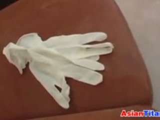 An asiatisch gives ein handjob mit latex handschuhe